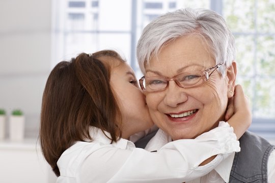 Little girl hugging and kissing granny