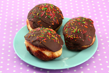Tasty donuts on color plate on color background