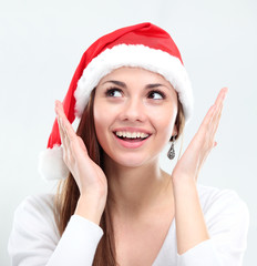 surprised christmas woman wearing a santa hat smiling isolated