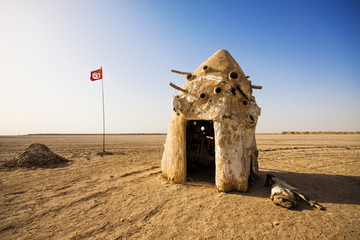 Old tent next to a Tunisian flag in the Sahara desert, Tunisia