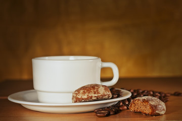 White cup of coffee with coffee beans and cakes