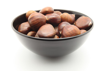 Black bowl with chestnuts isolated on white background