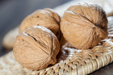Whole walnuts on straw background