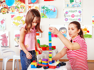 Child playing construction set with mother.