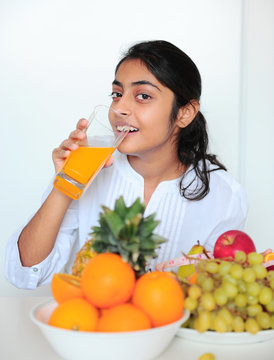 Beautiful girl holding fruits and a measure tape