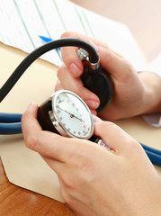 A doctor is measuring blood pressure with a tonometer