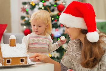 Fototapeta na wymiar Matka pokazuje Baby Christmas Gingerbread House