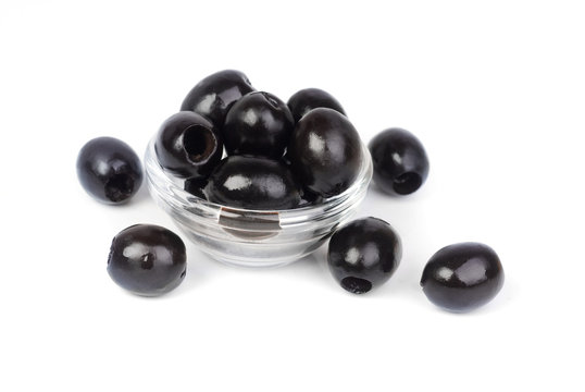 Black pitted olives in glass isolated on white macro