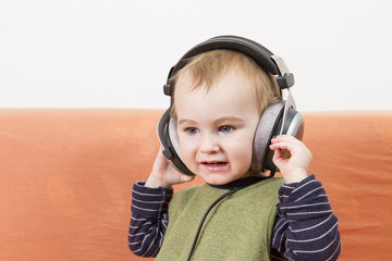 young child on couch with headphone