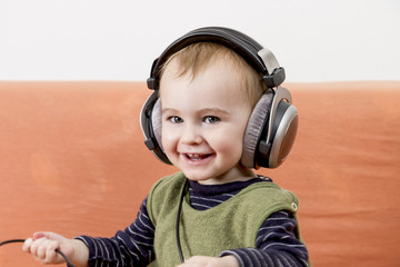 young child on couch with headphone