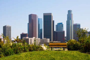 Naklejka premium Skyscrapers in Los Angeles with a bench in a foreground