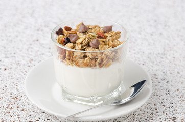 yogurt and granola with chocolate drops in a glass beaker