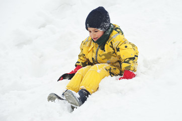 Fototapeta na wymiar Young kid having fun in the snow.