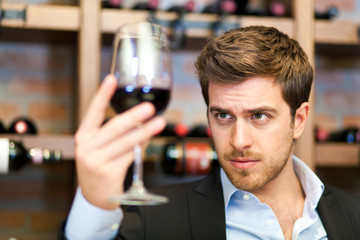 Man tasting a glass of red wine