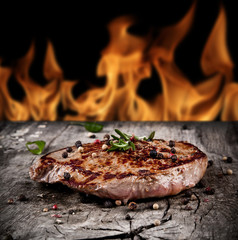 Délicieux steak de boeuf sur bois avec des flammes sur les arrière-plans