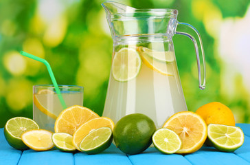 Citrus lemonade in pitcher and glass of citrus around