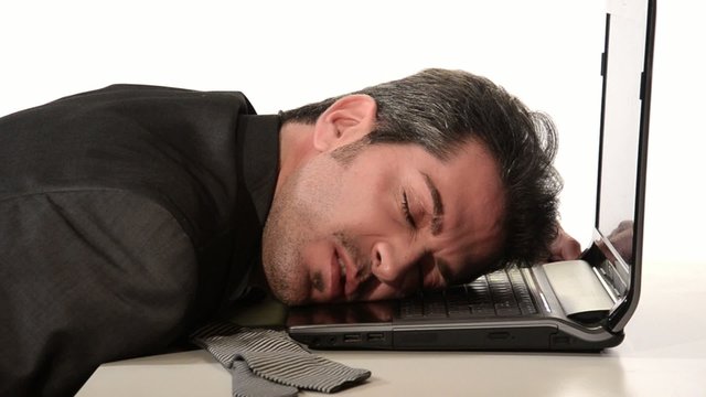 businessman resting head on laptop
