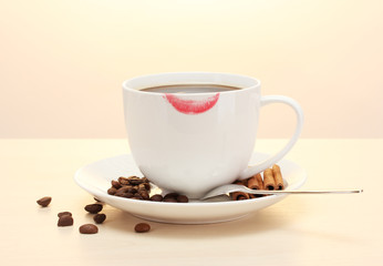 cup of coffee with lipstick mark beans and cinnamon sticks