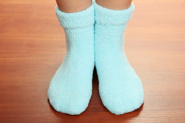 Legs female in blue socks on laminate floor