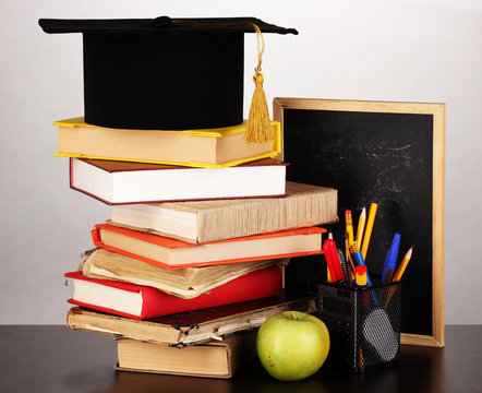 Books and magister cap against school board