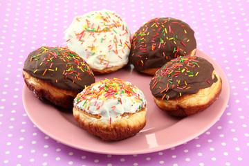 Tasty donuts on color plate on color background
