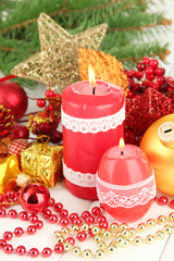 Red candle with christmas decoration on light background
