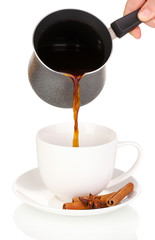 Pouring coffee in cup isolated on white
