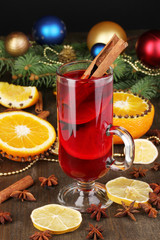 Fragrant mulled wine in glass with spices and oranges around