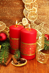 Two candles and christmas decorations, on golden background
