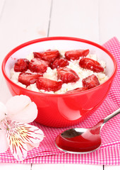 Cottage cheese in red bowl with sliced strawberries