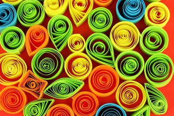 Colorful quilling on red background close-up