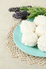 Marshmallows on color plate on light background