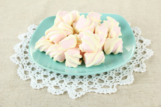 Marshmallows on color plate on light background