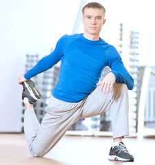 Man doing stretching exercises at the gym