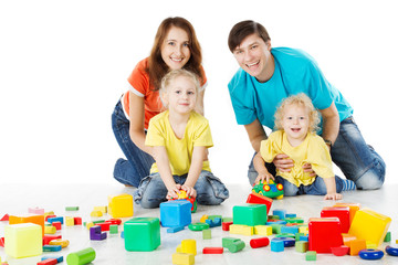 Happy family. Parents with three kids playing blocks over white