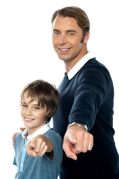 Charming father and son pointing at you