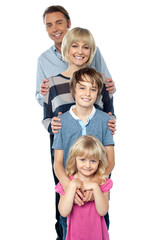 Sweet little family of four posing one behind the other