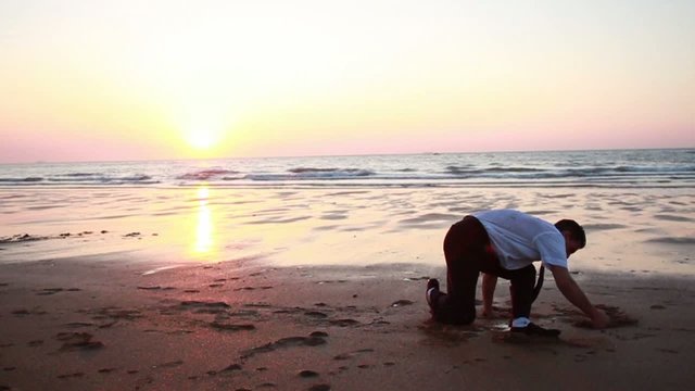 Homme pratiquant de la gymnastique sur la plage