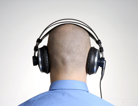 Vista trasera de hombre con aud&iacute;fonos,escuchando m&uacute;sica.