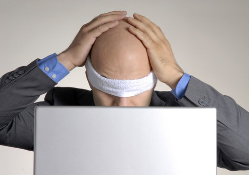 Hombre ejecutivo vendado frente a un ordenador,computador.