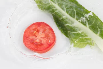  tomaat in water op witte achtergrond © schankz