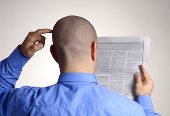 Hombre ejecutivo de espaldas leyendo periódico.