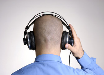 Vista trasera de hombre con audífonos,escuchando música.