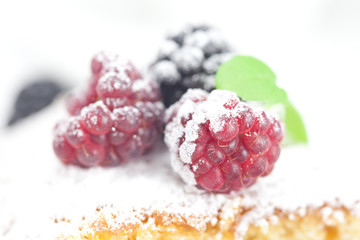 cup, cake, raspberry, blackberry,nuts and mint on a plate on a w