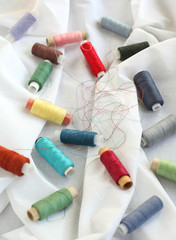 Fototapeta na wymiar Spools of threads on a cotton fabric