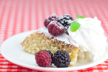 cake with icing,icecream, raspberry, blackberry and mint on a pl
