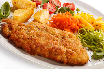 Pork chop, baked potatoes and vegetable salad