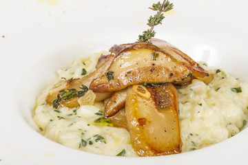 photo of delicious risotto dish with herbs and mushrooms on whit