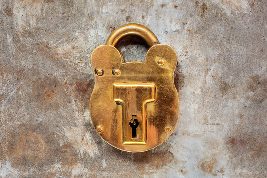 Vintage brass padlock on a steel rusty background
