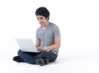 Young man sitting on the floor and work with laptop computer